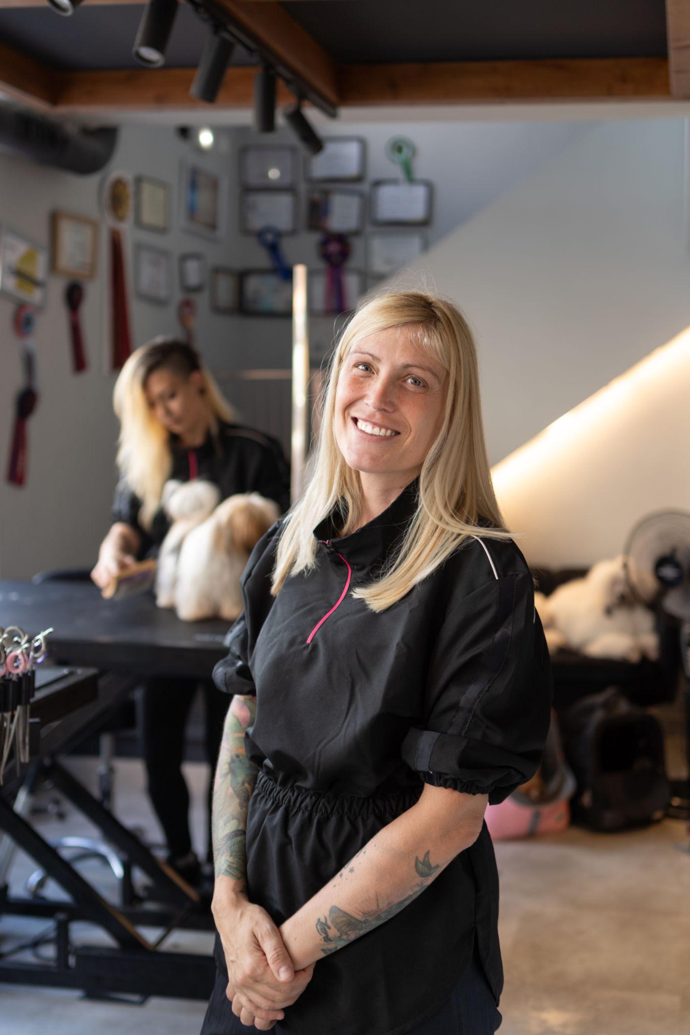 Groomer using phone with dog